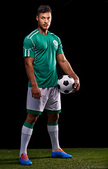 Image showing Man, ball and portrait for soccer, sport and match for fitness game and active for sportswear on grass or field. Role model or athlete and practice with kit for competitive on dark background