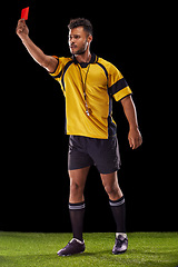 Image showing Sports, referee or man with a red card for warning, foul call or penalty review in football game on turf. Soccer match, discipline or male person with punishment, rules or caution on black background