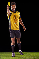 Image showing Portrait, referee or man with a yellow card for warning, foul call or penalty review in sports game on turf. Soccer match, discipline or person with punishment, rules or caution on black background