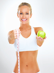 Image showing Fitness, woman and portrait with apple and measuring tape for exercise, health and wellness for diet in studio. Model, dietician or nutritionist with fruit for cleanse, strength and vitamin for detox