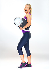 Image showing Woman, portrait and scale in studio for results, smile and excited for progress of diet or detox. Female person, laugh and happy for calories burned target or goals, wellness and white background