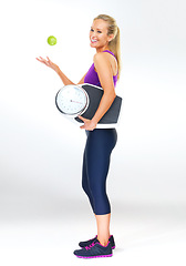 Image showing Woman, portrait and scale or apple for balance, studio and excited for results of diet or detox. Female person, nutrition and journey for calories burned target, organic snack and white background