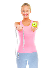 Image showing Woman, portrait and studio with apple and measuring tape for healthy or slim body, dietitian or nutritionist for fit figure. Person, happy and fruit for diet and exercise for wellness or self care