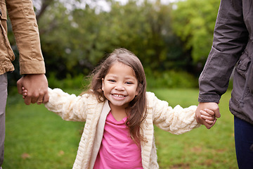 Image showing Portrait, parents and child holding hands in park with smile, support and trust on outdoor adventure. Love, fun and face of girl with family in garden for happy holiday, nature or walking in backyard