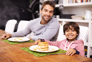 Image showing Portrait, father and child with breakfast in morning with smile, happiness and bonding with food. Family, man and kid in kitchen at home hungry, eating and nutrition with meal for energy in house