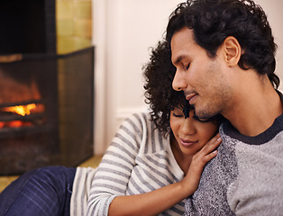 Image showing Couple, fireplace and relax in embrace, home and peace or calm and proud of marriage or commitment. People, holding and hugging on floor in lounge on weekend, support and trust in relationship