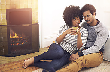 Image showing Couple, fireplace and relax for care and date in home, security and proud of marriage and commitment. People, coffee and bonding on floor in lounge on weekend, support and trust in relationship