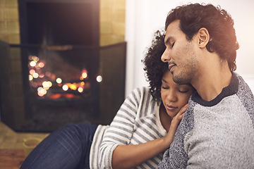 Image showing Couple, fireplace and relax in hug, home and peace or calm and proud of marriage or commitment. People, love and embrace on floor in living room on weekend, support and trust in relationship