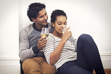 Image showing Couple, floor and wine for celebration and embrace in home, smile and proud of marriage and commitment. People, milestone and drinking in living room on weekend, support and alcohol for relationship