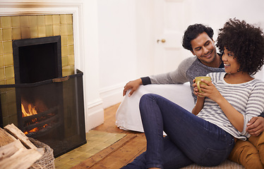 Image showing Couple, fireplace and relax for care and love in home, smile and proud of marriage and commitment. Happy people, coffee and date on floor in lounge on weekend, support and trust in relationship