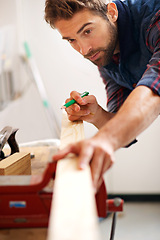 Image showing Carpenter, pencil and man with wood for home improvement, building renovation and woodwork in garage. Lumber, measuring and male employee for diy, furniture restoration or manufacturing on project