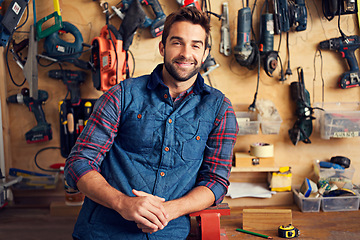 Image showing Tools, carpenter and portrait of man in garage for home development, construction and renovation in workshop. Smile, male employee and contractor for maintenance, equipment and repair work for diy