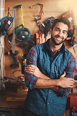 Image showing Tools, portrait and man with arms crossed in workshop for diy, home development or renovation. Handyman, carpenter and happy male employee for maintenance, equipment and repair work for construction