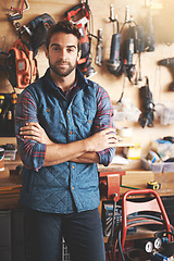 Image showing Man, portrait and tools with arms crossed for diy, home development and renovation in workshop. Carpenter, lens flare and male employee for maintenance, equipment and repair work for construction