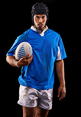 Image showing Rugby, portrait and man in studio for fitness, competition and sportswear in isolated dark background. Ball, player and young male athlete with confidence for professional sport, workout or exercise