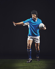 Image showing Defend, man and ball for rugby sport or training for workout, fitness and skill for competition. Person or player on grass and athlete stop with hand or active for football game on black background.