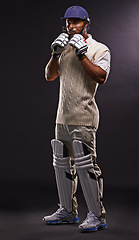 Image showing Man, cricket and athlete for sports match with confidence in studio on black background or exercise, fitness or game. Male person, helmet and gear for professional competition, training or mockup