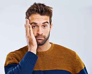 Image showing Bored man, portrait and headache with stress, depression or anxiety on a white studio background. Young guy, tired model or upset male person in mistake, disappointed or mental health on mockup space