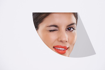 Image showing Portrait, woman and makeup or beauty in cutout in studio for cosmetics, skincare and dermatology with wink. Face of model or young person with foundation in geometric mockup on a white background