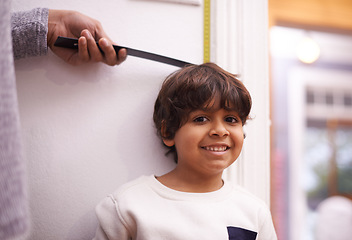 Image showing Child, portrait and measure height growth with ruler for childhood development, taller or elementary school. Boy, student and face with hand or tape at wall in apartment for checking, size or happy