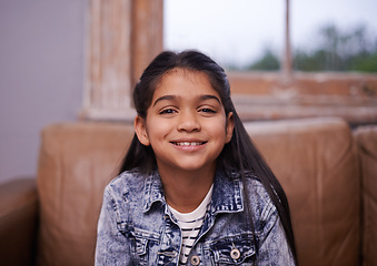 Image showing Smile, portrait and girl child on sofa in living room with positive, good and confident attitude. Happy, sweet and face of cute young kid sitting on couch for relaxing in lounge at modern home.