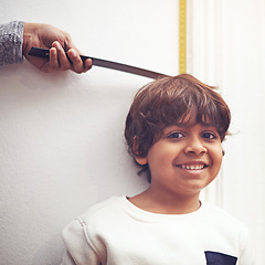 Image showing Child, portrait and height measure at wall for growth development in home with ruler, tape or smile. Boy, face and hand with marking for childhood chart in home for checking size, tall or happiness