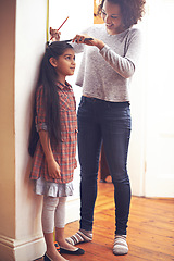 Image showing Mother, child and measuring tape for height with ruler at wall for growth development in home, childhood or bonding. Female person, daughter and pencil in apartment for size checking, youth or parent