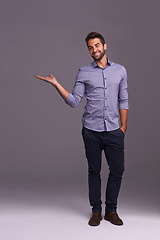 Image showing Happy man, portrait and advertising with palm for marketing, presentation or showcase on a gray studio background. Young and handsome male person or employee with smile showing option on mockup space