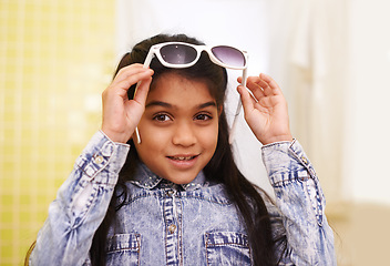 Image showing Girl, portrait and sunglasses for home, holiday and vacation with fashion and cool style. Happy face of a young Mexican kid or child with smile, casual and trendy accessory or shades for fun indoors