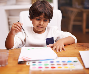 Image showing Little boy, painting and drawing with brush on paper for art, design or creativity with color at home. Young child or kid with smile and paintbrush for colorful palette, artwork or artistic skills