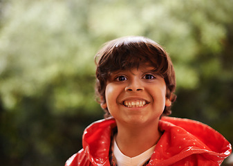 Image showing Rain, smile and portrait of boy in a forest for adventure, freedom or exploring games in nature. Winter, travel and face of excited kid in India outdoor for learning, journey or freedom in a storm