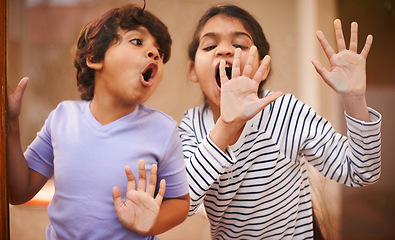 Image showing Window, face and funny siblings with hand press comic in a house with silly, joke or goofy gesture. Glass, palm or Indian kids with humor, games or playing on vacation, holiday or weekend in India