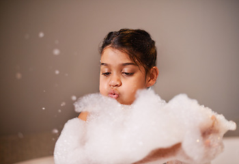 Image showing Bath, blowing bubbles or girl with soap in a house for body care, washing or cleaning. Bathtub, face and playful kid in bathroom with wellness skincare cosmetics, hygiene or fun with water splash