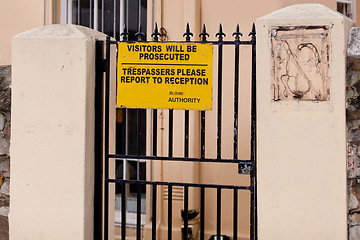 Image showing Sign, outdoor and warning with gate, building and authority with board and street with design. Notice, urban town and outside with road or safety with protection and review with information or poster