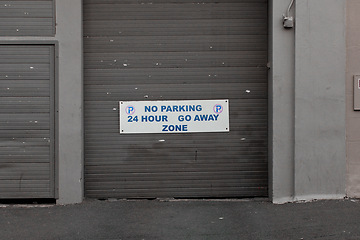 Image showing Parking lot, building and sign on door with information, notification and message on private property. Signage, symbol and mistake on poster, board and attention for warning, car and vehicles in city