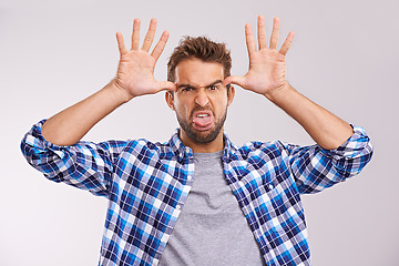 Image showing Man, portrait and funny face in studio for goofy humor on white background for good mood, expression or mockup space. Male person, hands and tongue out with gesture for comedy joke, tease or playing