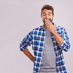 Image showing Hand cover mouth, yawn and man with burnout, tired and low energy on a grey studio background. Person, mockup space and exhausted with model and fatigue with emoji, sleepy and lazy with bored gesture