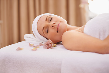 Image showing Woman, spa and rest for zen, wellness and peace with relaxation and calm. Lady, towel and massage table at resort, lounge or luxury parlor with rose for holistic body and skincare for detox and break