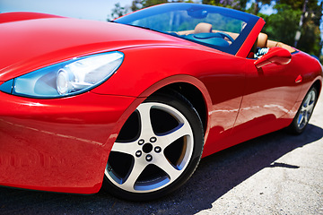 Image showing Luxury, sports car and driving closeup with wheel in city, outdoor in summer and person on road trip. Red, convertible and rich driver with transport to travel on highway and vehicle on street