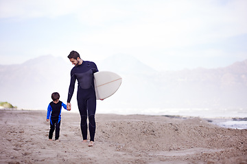 Image showing Surfboard, man and child on beach, walking and holding hands on outdoor bonding adventure. Nature, father and son at ocean for surfing, teaching and learning together with support, trust and growth.