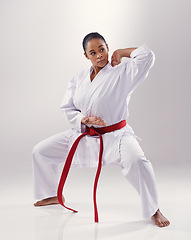 Image showing Woman, training and karate fighter in studio, fitness and martial arts on white background. Black person, athlete and red belt for taekwondo, discipline and warrior ready for self defense or battle