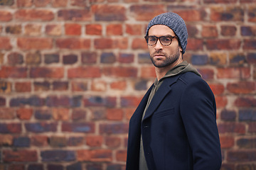 Image showing Man, portrait and urban fashion by brick wall downtown for aesthetic, modern and vacation for city culture. Male person, trendy winter clothes for streetwear style for creative career in New York