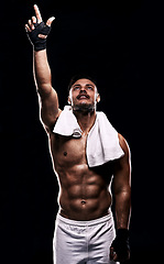 Image showing Man, boxer and hand in studio for faith, fitness and pointing up for training on black background. Person, athlete and strong muscles for workout or exercise, religion and battle or competition