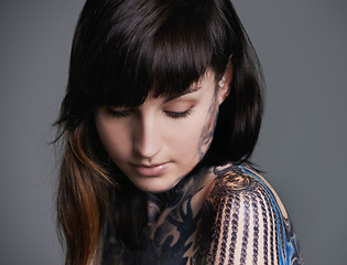 Image showing Woman, tattoo and design for creativity in studio with creative ink, trendy and body art with color. Female person, funky and edgy with artistic or blue for bold statement in gray background