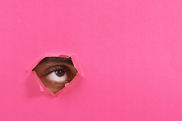 Image showing Tear, hole and eye of person on pink background for vision, eyesight and looking for inspiration. Mockup space, creative aesthetic and isolated eyes in studio for thinking, wondering or announcement