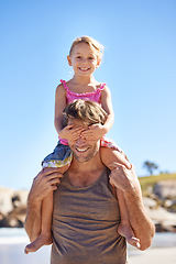 Image showing Portrait, dad and shoulder to carry girl for family, game and bonding together on summer beach day. Blue sky, papa and young daughter for fun walk, happiness and sunshine on vacation in Spain