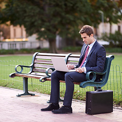 Image showing Park, bench and business man with a laptop, typing and connection with deadline or online reading. Person, employee or entrepreneur with a computer or thinking with check project schedule or internet