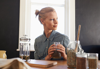 Image showing Woman, thinking and herbal tea to relax in home and warm beverage of herbs mixture for health. Happy, designer and creative idea for dried leaves in plunger and wellness for detox drink in mason jar
