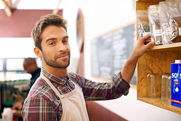 Image showing Man, barista and portrait by a shelf in coffee shop with smile for service, search and ingredients for drink. Waiter, person or small business owner in cafe with product, beans and happy for choice