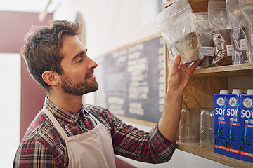 Image showing Man, waiter and check by shelf in a coffee shop with idea for service, search or ingredients for drink. Barista, person or small business owner in a cafe with product, beans and thinking for decision